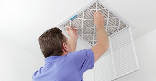 Man replacing vent filter