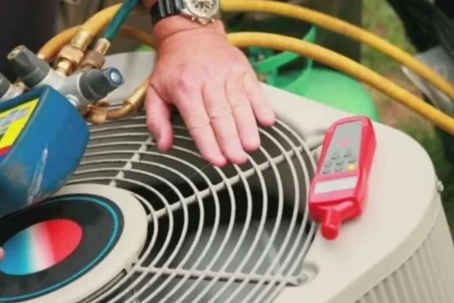 hand resting on top of an AC unit